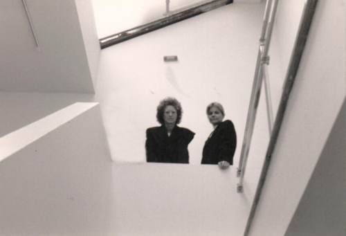 Cofounders Helene Winer and Janelle Reiring gazing down from staircase