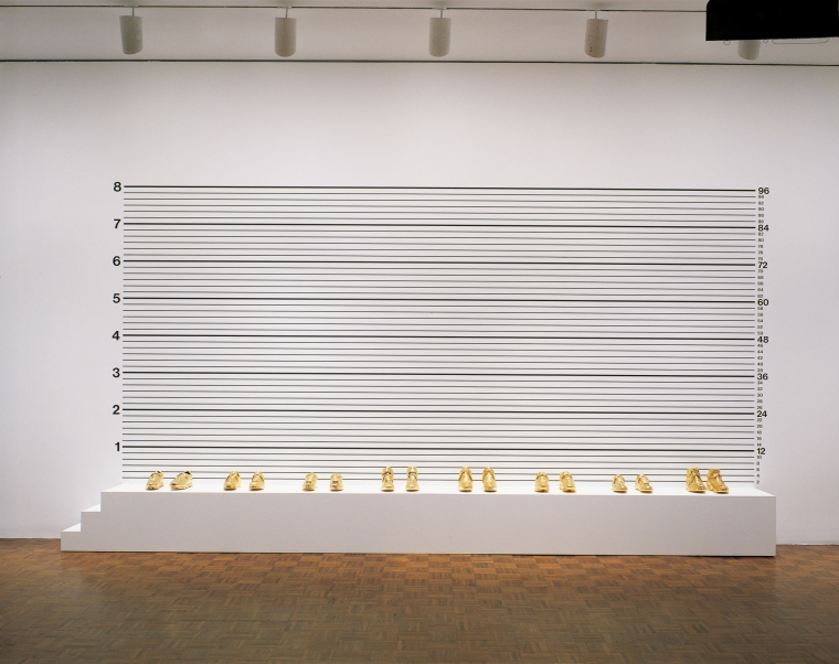 Lineup, 1993. Synthetic polymer on wood, gold-plated shoes, 114 x 216 x 18 inches (289.6 x 548.6 x 45.7 cm).